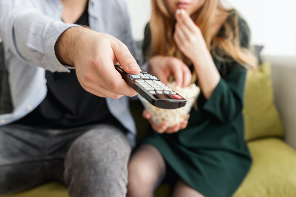 un uomo e una donna sul divano decidono cosa guardare